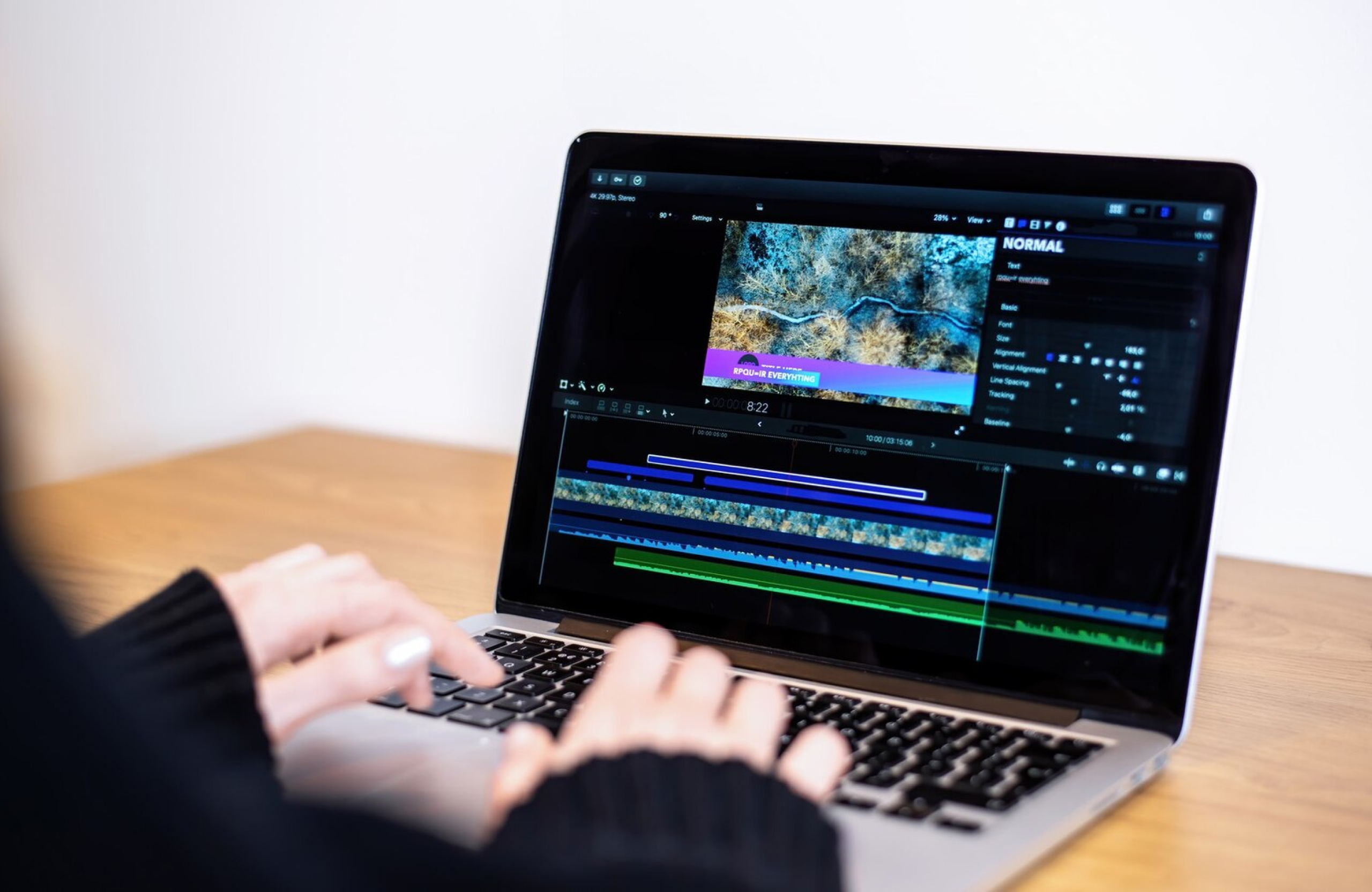 FX Productions Canada Person editing a video on a laptop with video editing software open, displaying a timeline and various editing panels. Toronto Video Production Company
