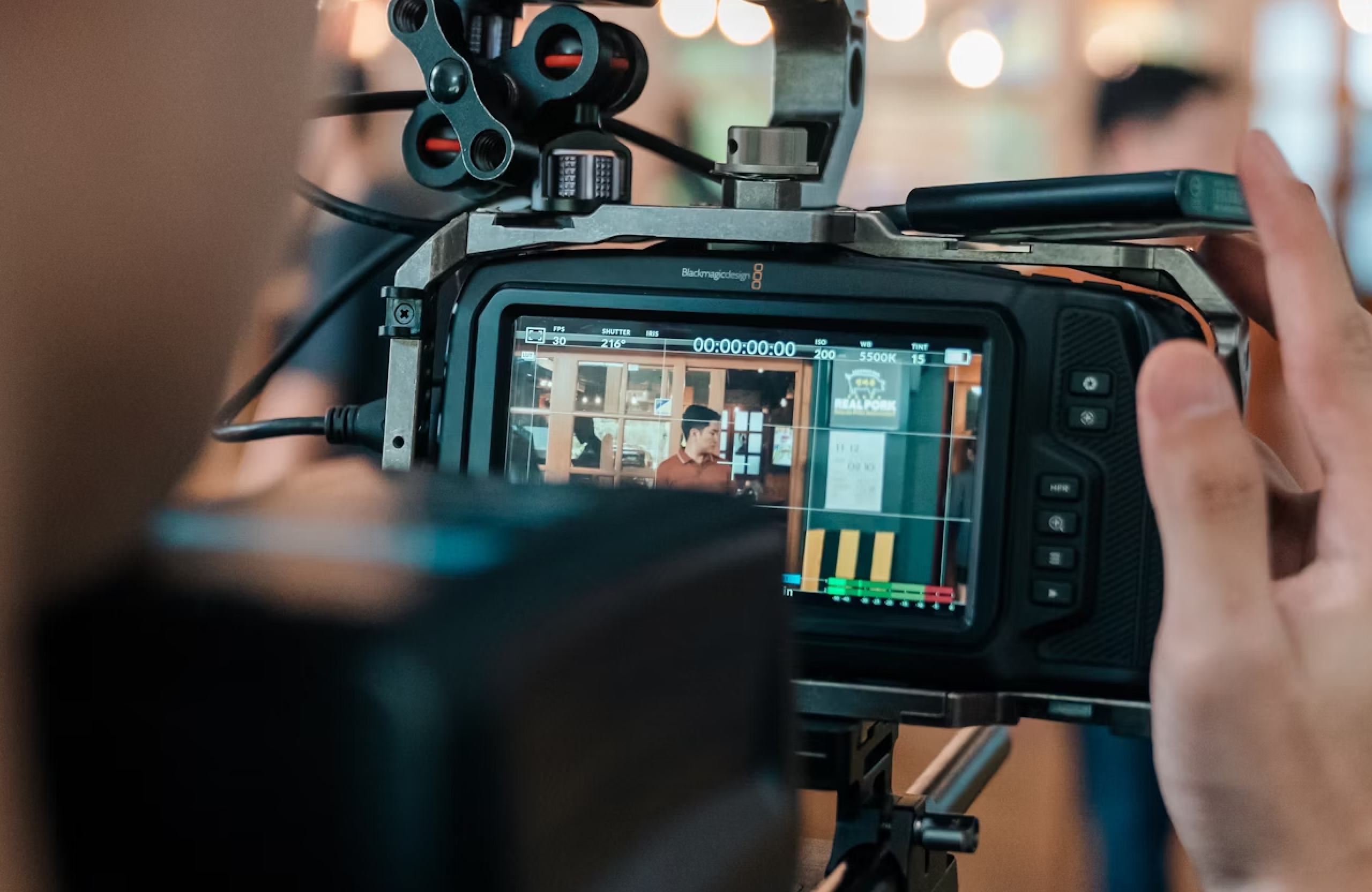 FX Productions Canada A close-up of a camera monitor displays a person standing indoors, while a hand adjusts the camera settings during filming. Toronto Video Production Company