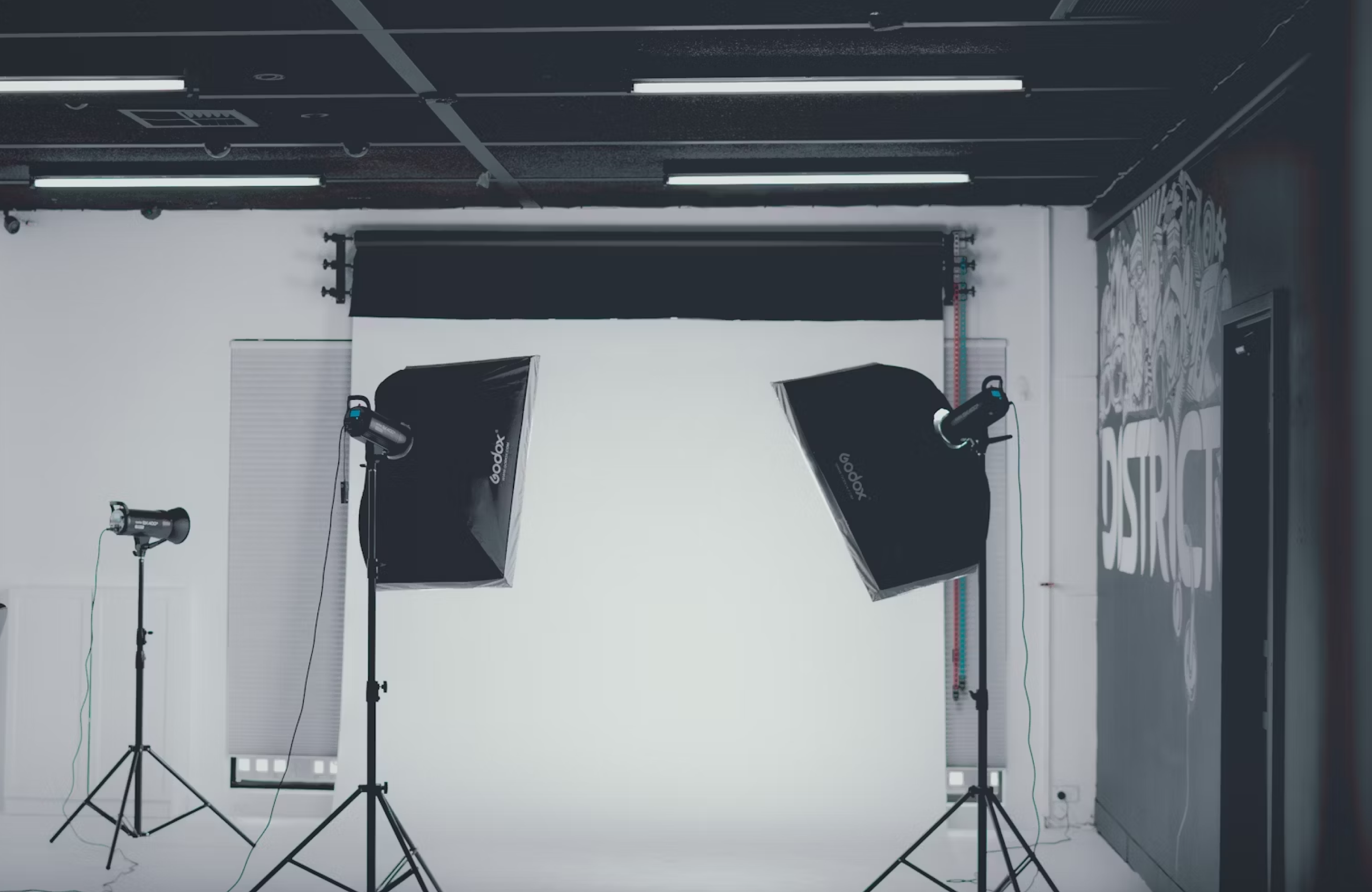 FX Productions Canada A photography studio setup with two large softbox lights and one smaller light on stands positioned in front of a white backdrop. Toronto Video Production Company