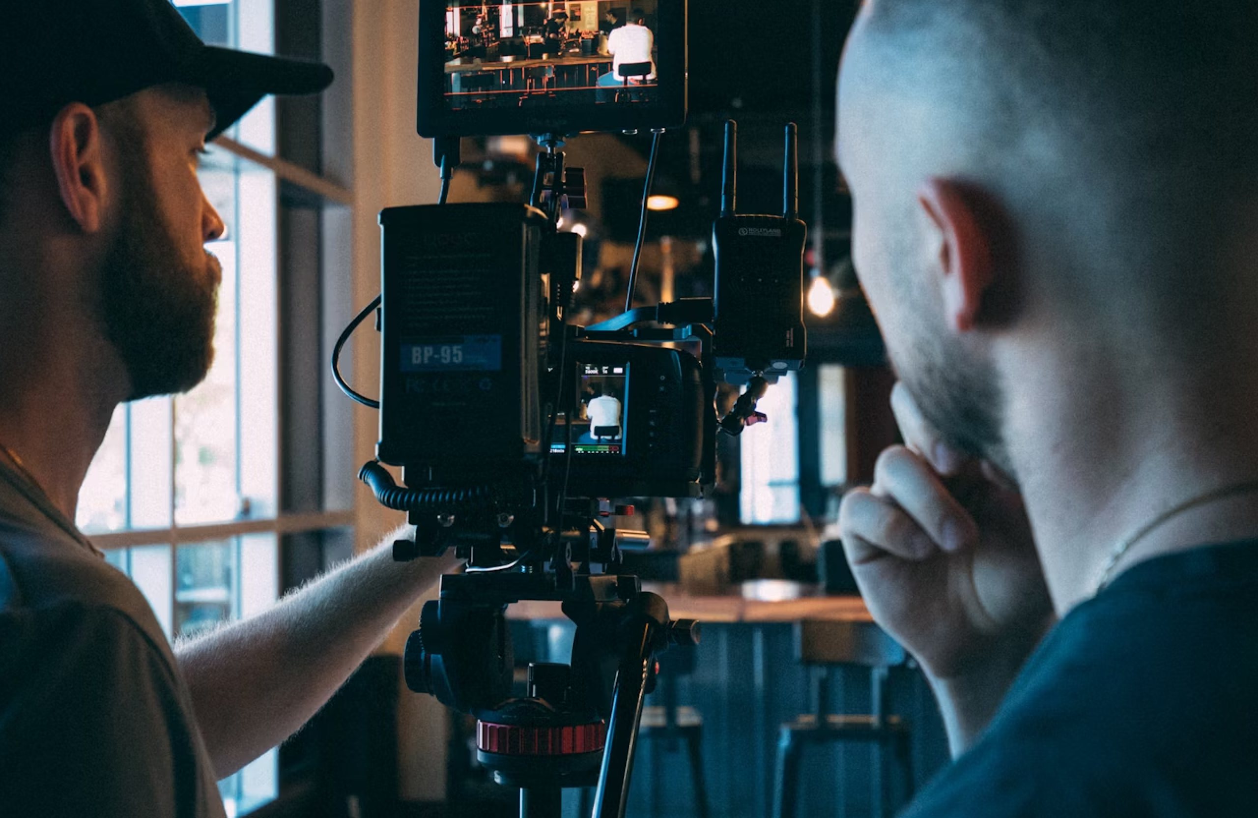 FX Productions Canada Two people operate a professional video camera setup indoors, focusing on a scene displayed on the camera monitor. Toronto Video Production Company