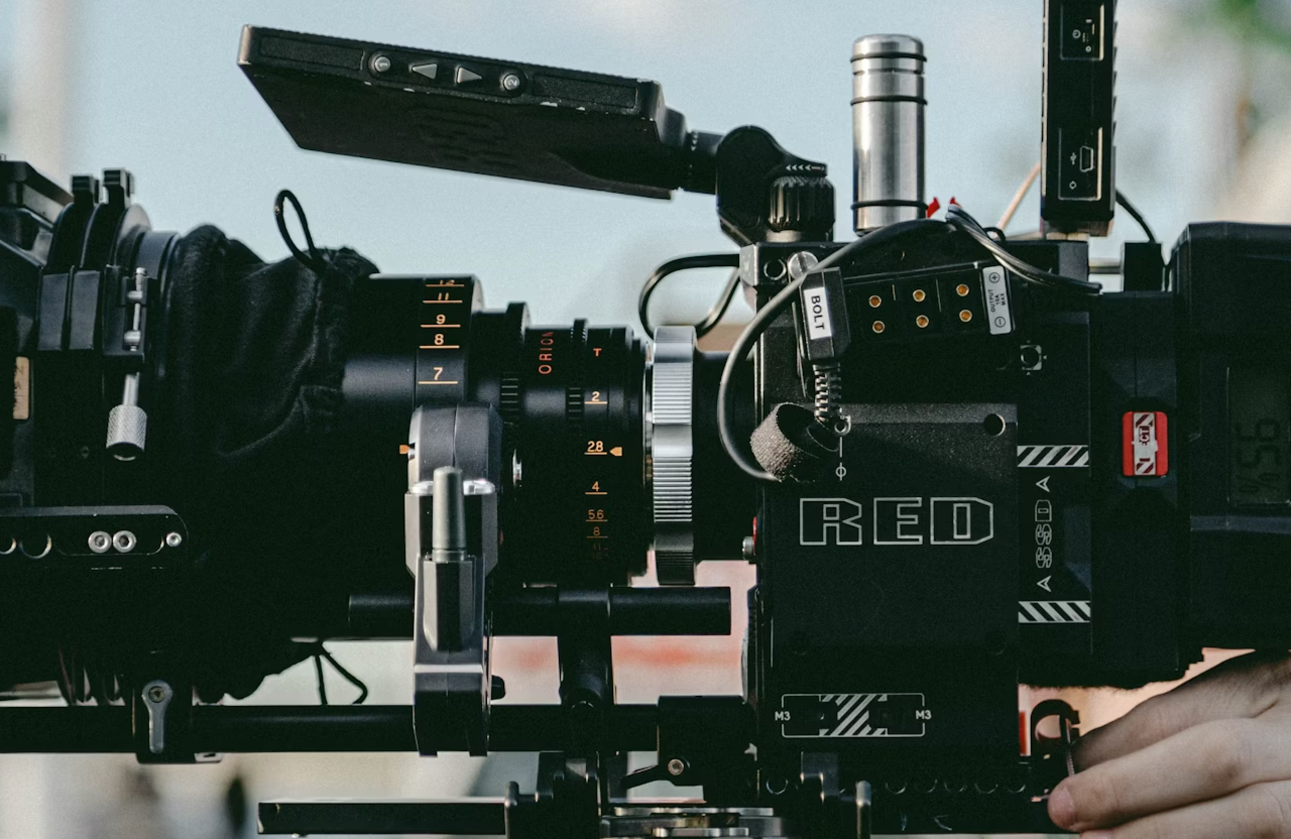 FX Productions Canada Close-up of a professional RED digital cinema camera setup with a large lens and attached accessories, positioned for filming by a full-service production company. Toronto Video Production Company