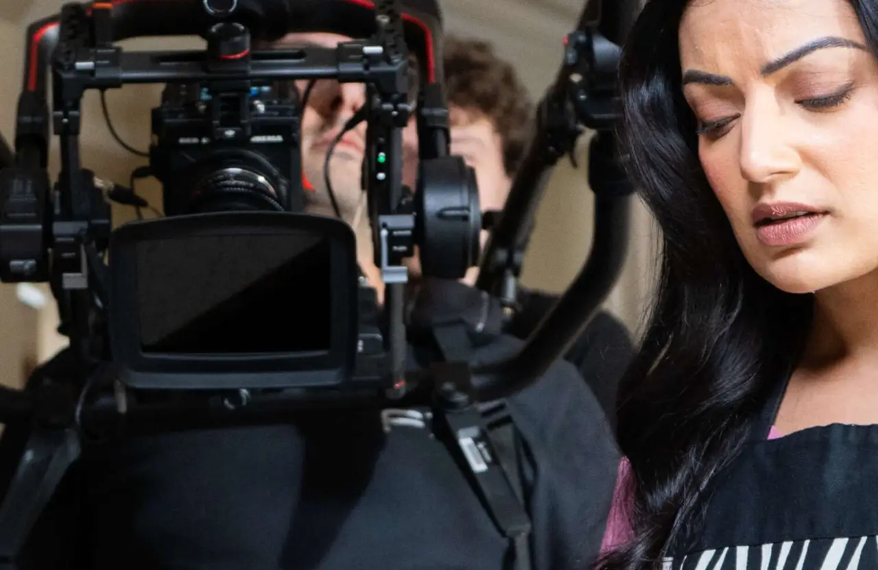 FX Productions Canada A camera operator from a full service video production company films a woman in an apron, who is looking down; the focus is on the filmmaking equipment and her concentrated expression. Toronto Video Production Company