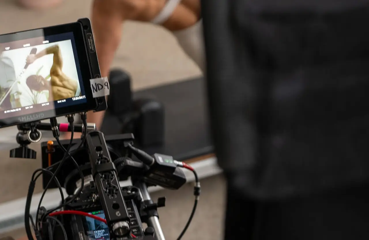 FX Productions Canada A close-up of a video camera setup filming a person exercising, with the subject's image displayed on the camera monitor—showcasing expert skills often seen in automotive video production Toronto. Toronto Video Production Company