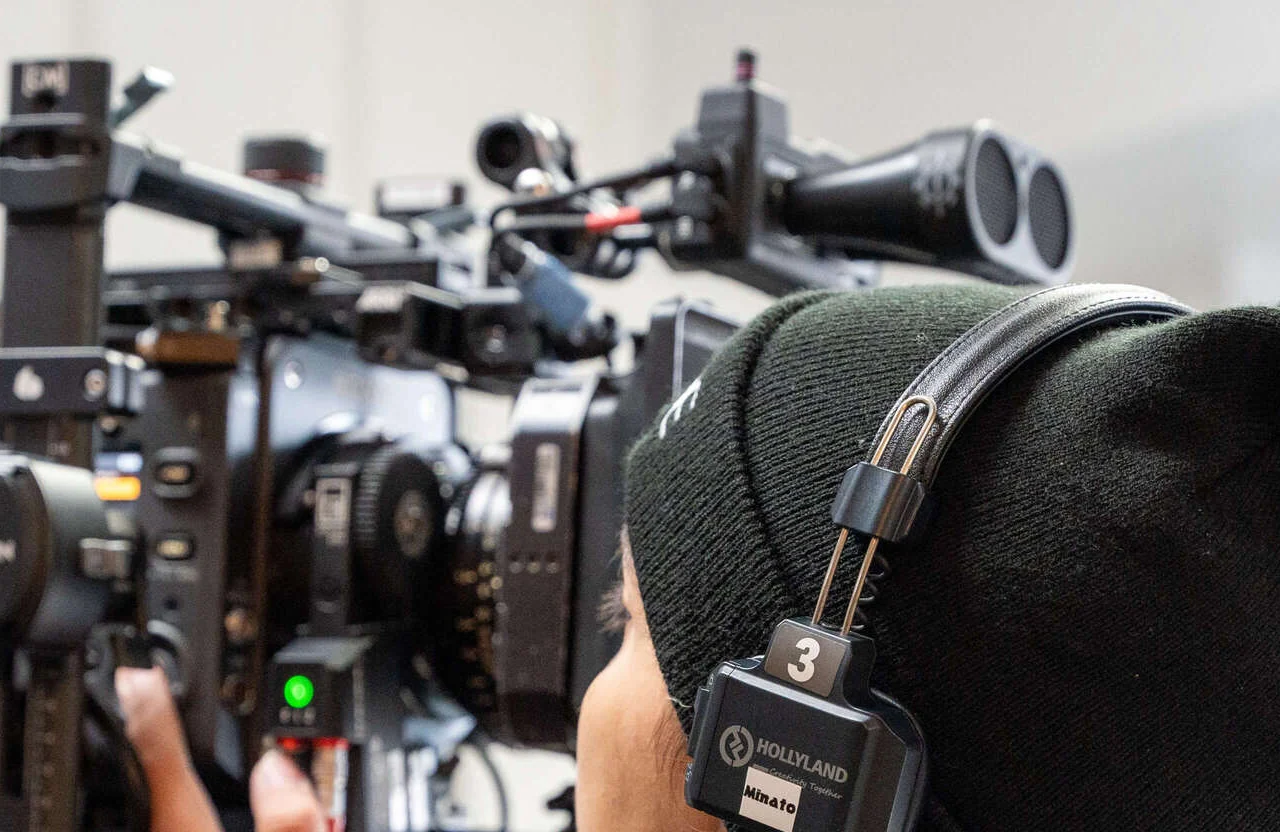FX Productions Canada A person wearing a headset and black beanie operates a professional video camera with various attachments and controls in close-up view, exemplifying how Canadian brands are raising their video standards. Toronto Video Production Company