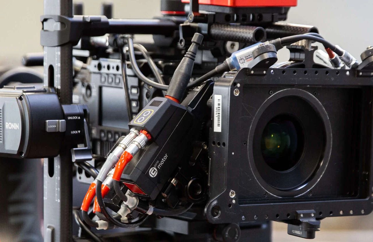 FX Productions Canada Close-up of a professional cinema camera rig with various cables, lens, electronic components, and mounted accessories visible—showcasing the advanced tools that ensure video production supports brand expansion effectively. Toronto Video Production Company