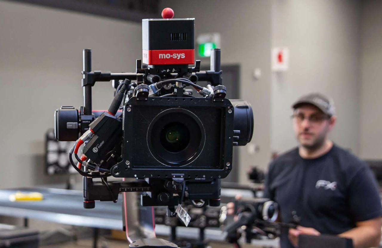 FX Productions Canada A professional camera rig with a mo-sys system is mounted on a tripod, illustrating the evolution of commercial video production, with a person wearing a cap blurred in the background. Toronto Video Production Company