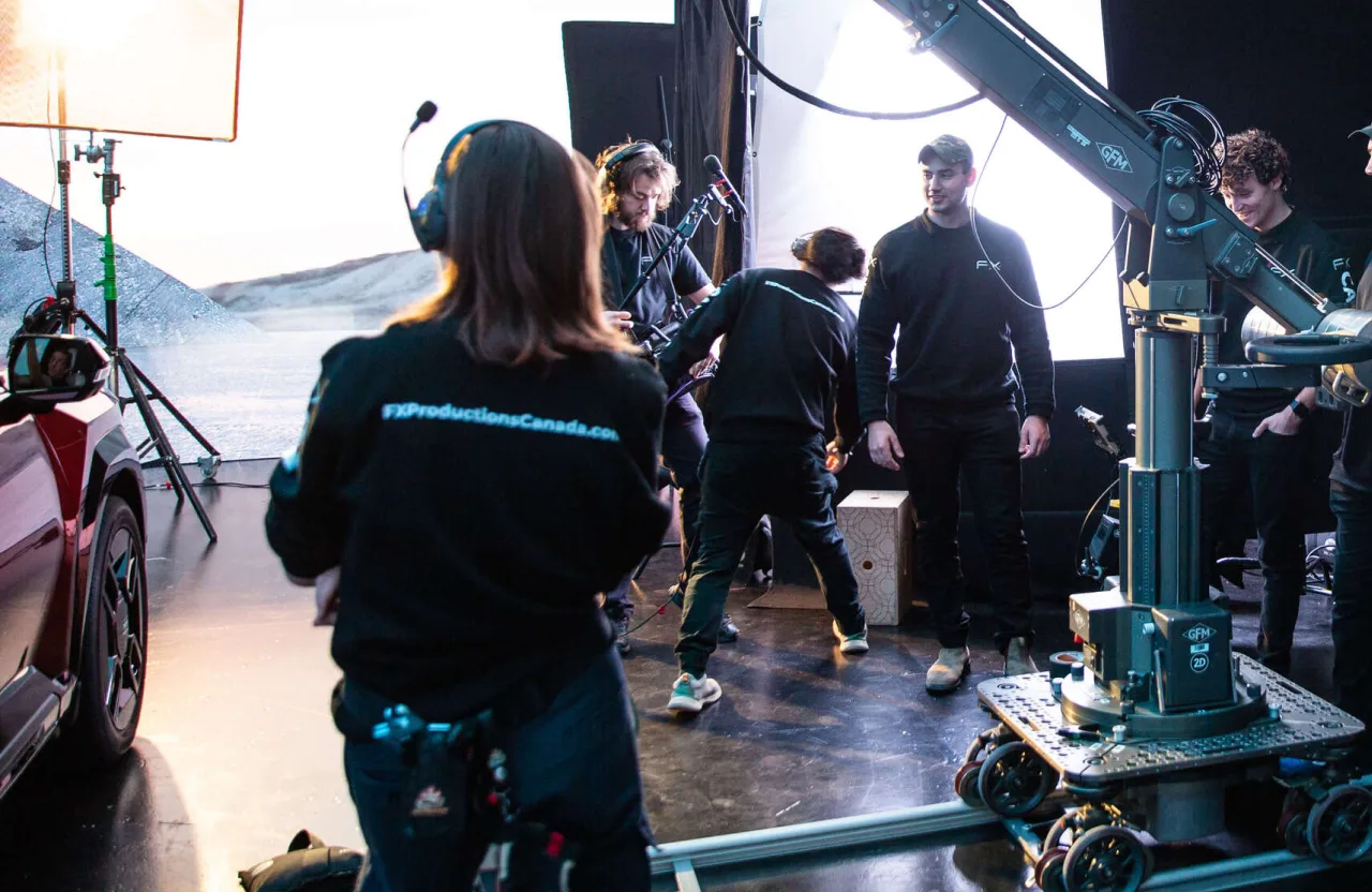 FX Productions Canada Film crew members set up equipment and lighting on a studio set, with cameras and monitors visible; some staff wear headsets and branded clothing, emphasizing how strategic video beats high-volume content when creating impactful productions. Toronto Video Production Company