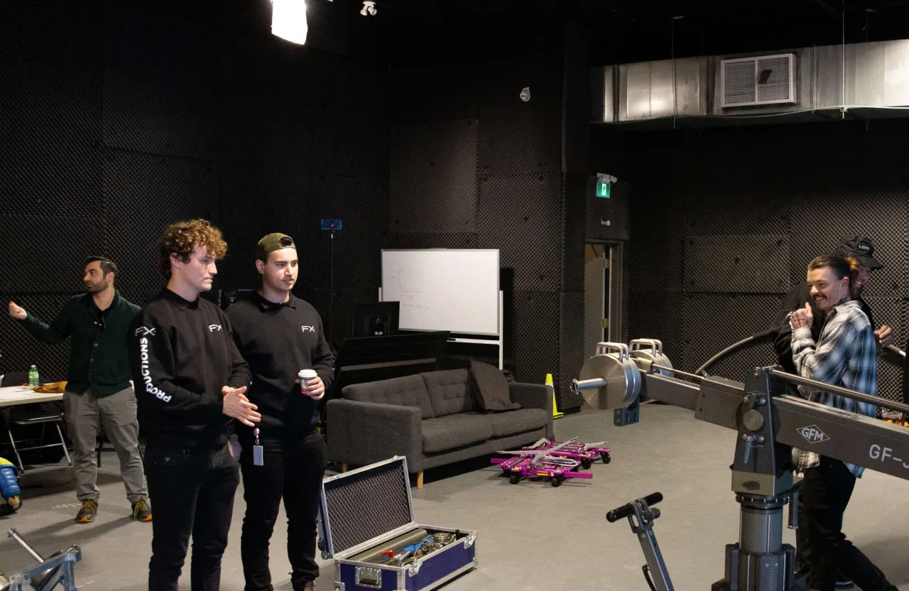 FX Productions Canada Five people stand in a studio with film equipment, a sofa, and a table visible. As they collaborate near the camera rig and case, their dynamic reflects the latest video production trends shaping modern studios. Toronto Video Production Company