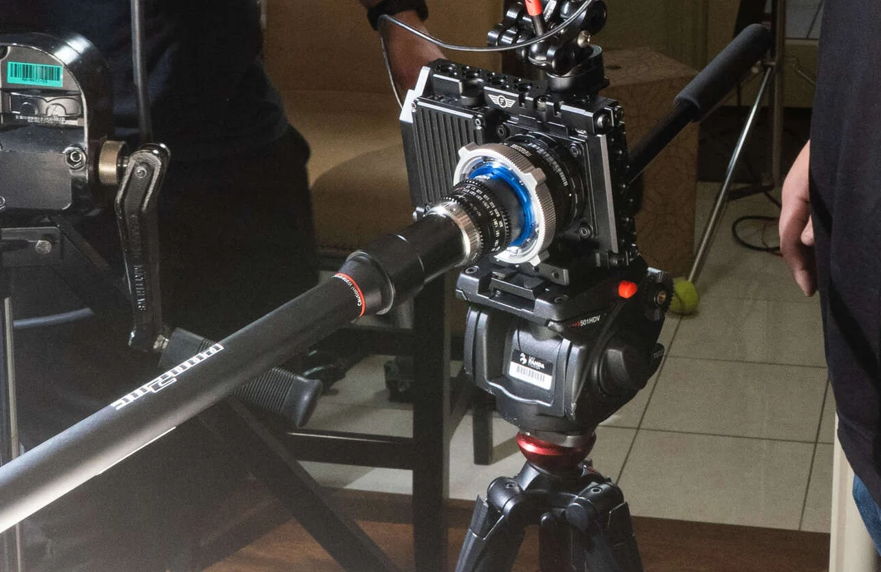 FX Productions Canada A professional camera is mounted on a tripod with a long lens attached; some equipment and people—working to align video production with marketing goals—are partially visible in the background. Toronto Video Production Company