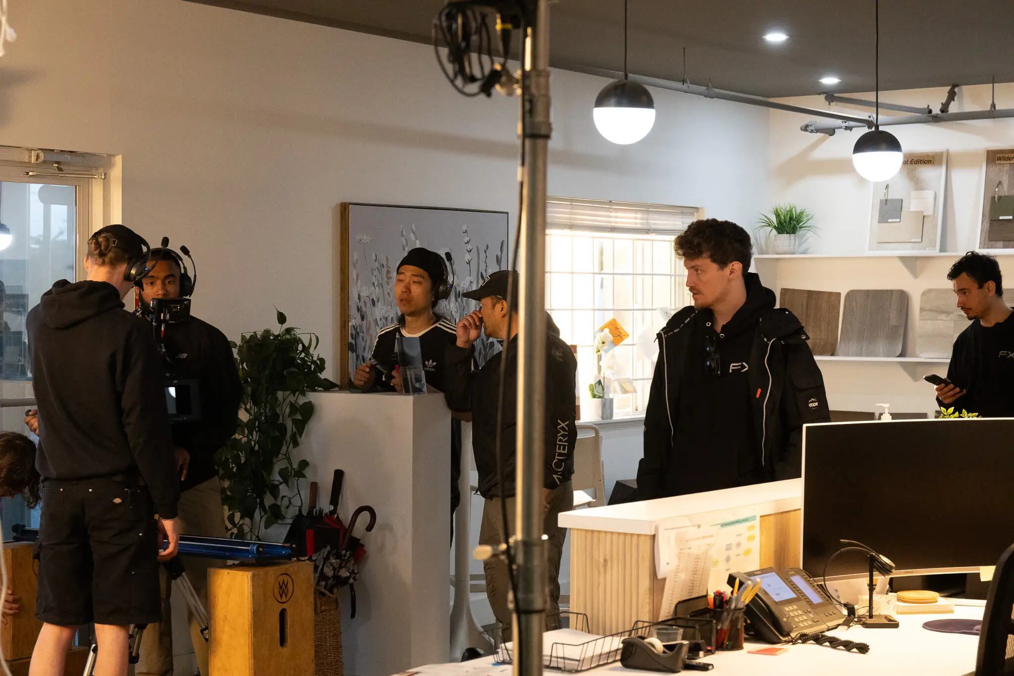 FX Productions Canada A documentary video production crew sets up equipment and prepares in a Vancouver office space with desks, computers, and lighting. Several people are gathered, some holding cameras and others talking or using phones. Toronto Video Production Company