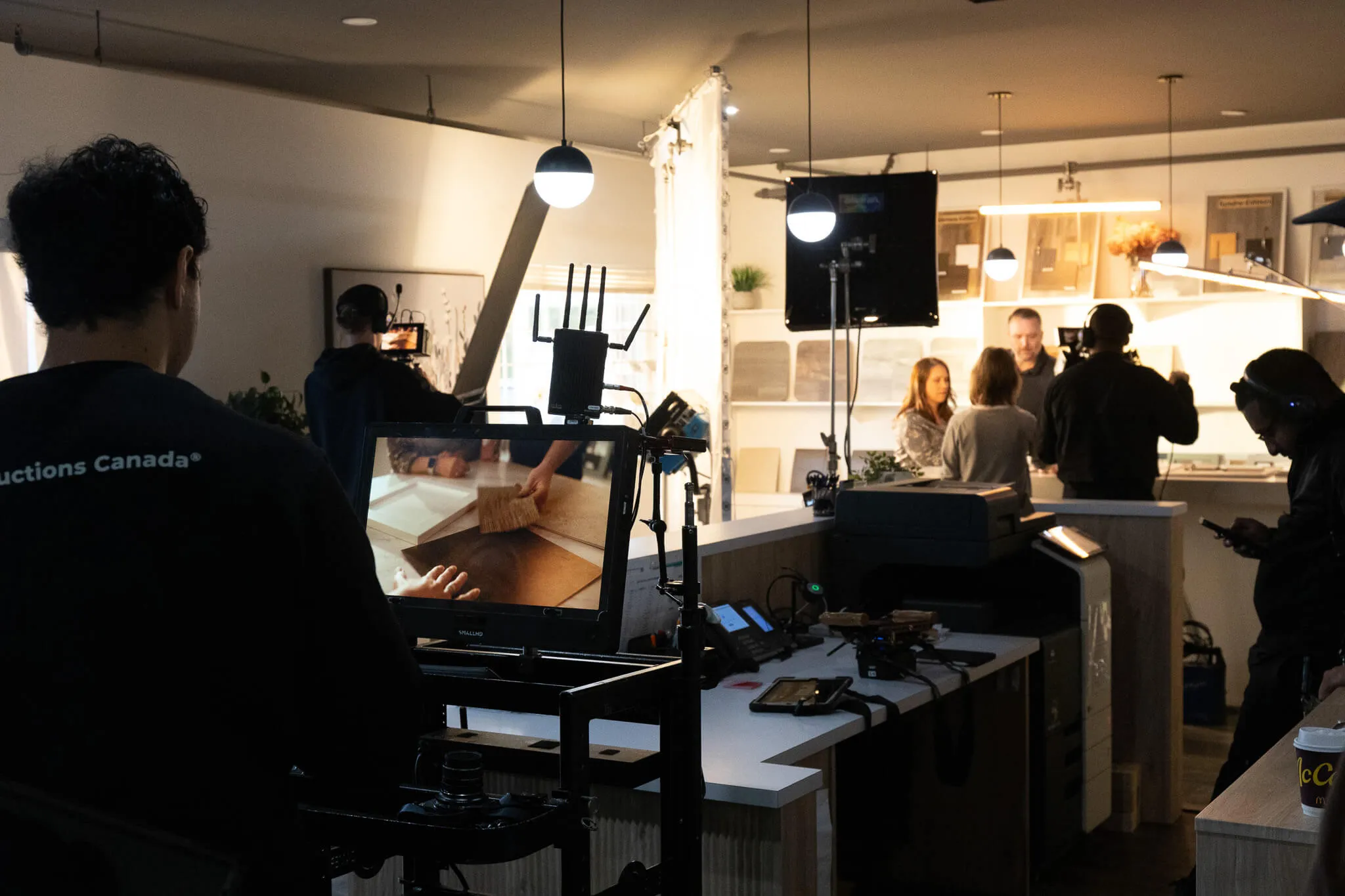 FX Productions Canada A film crew from a hire video production company Vancouver records a scene in a modern kitchen set, with actors interacting while a camera operator films and monitors the footage. Toronto Video Production Company