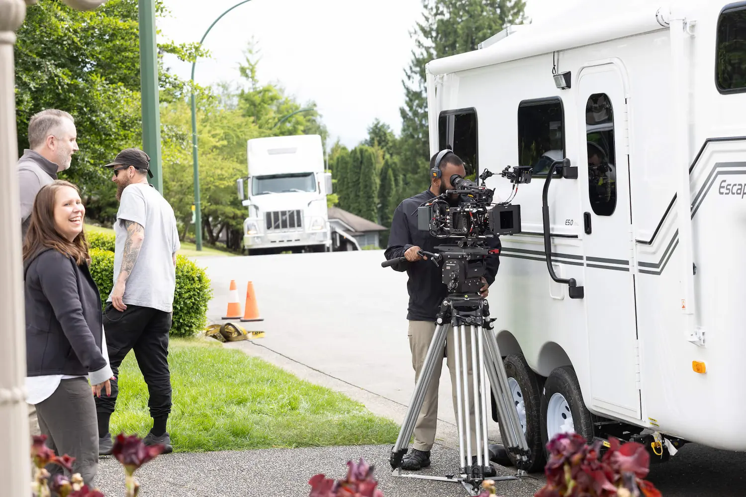 FX Productions Canada A film crew sets up a camera outside a white trailer on a suburban street while several people stand nearby, discussing techniques like how do they film drowning scenes safely in movies. Toronto Video Production Company