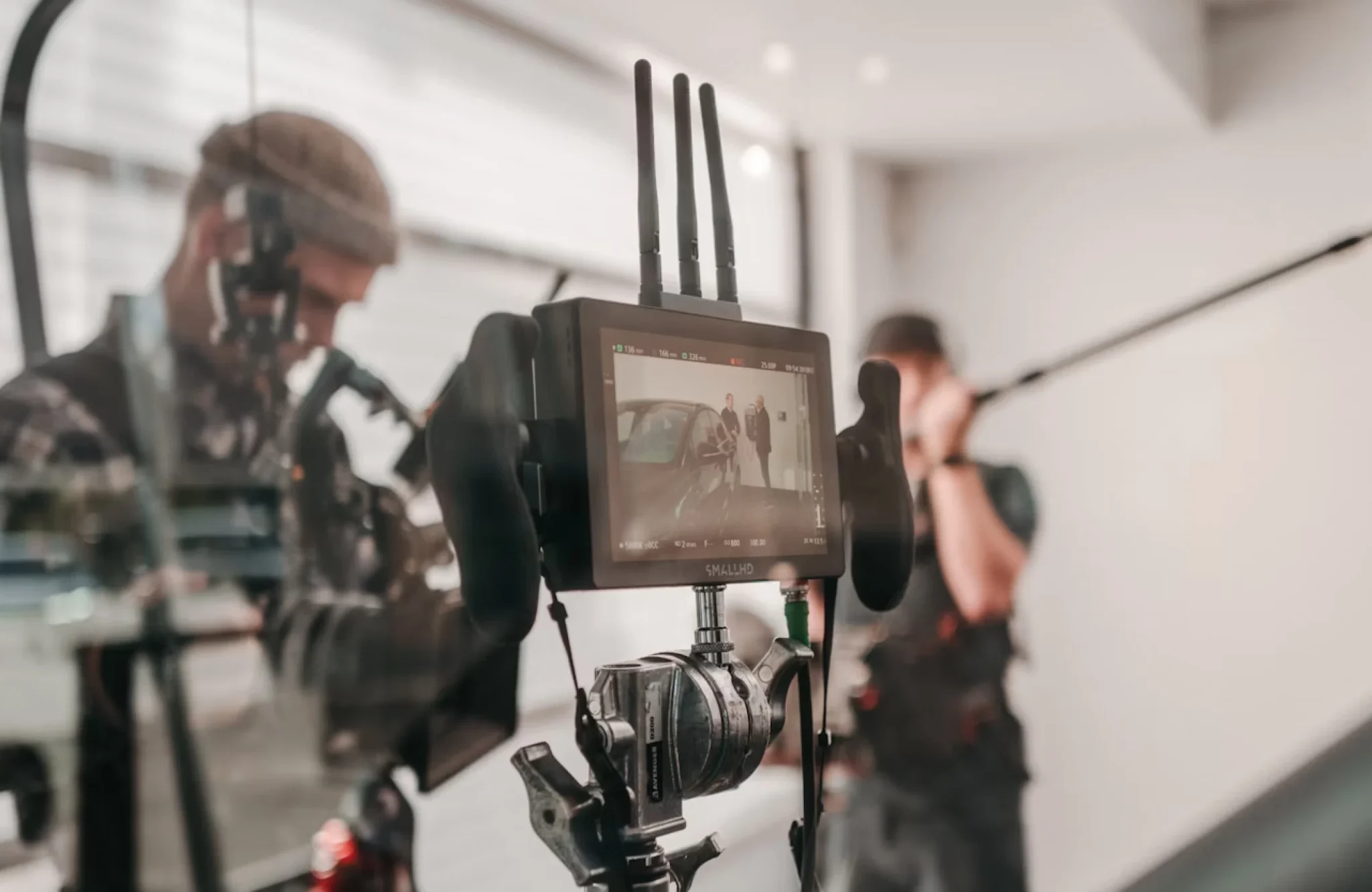 FX Productions Canada A camera monitor displays a film scene with two crew members visible in the background, one holding a boom microphone—capturing the energy of a connected TV commercial production in Canada. Toronto Video Production Company