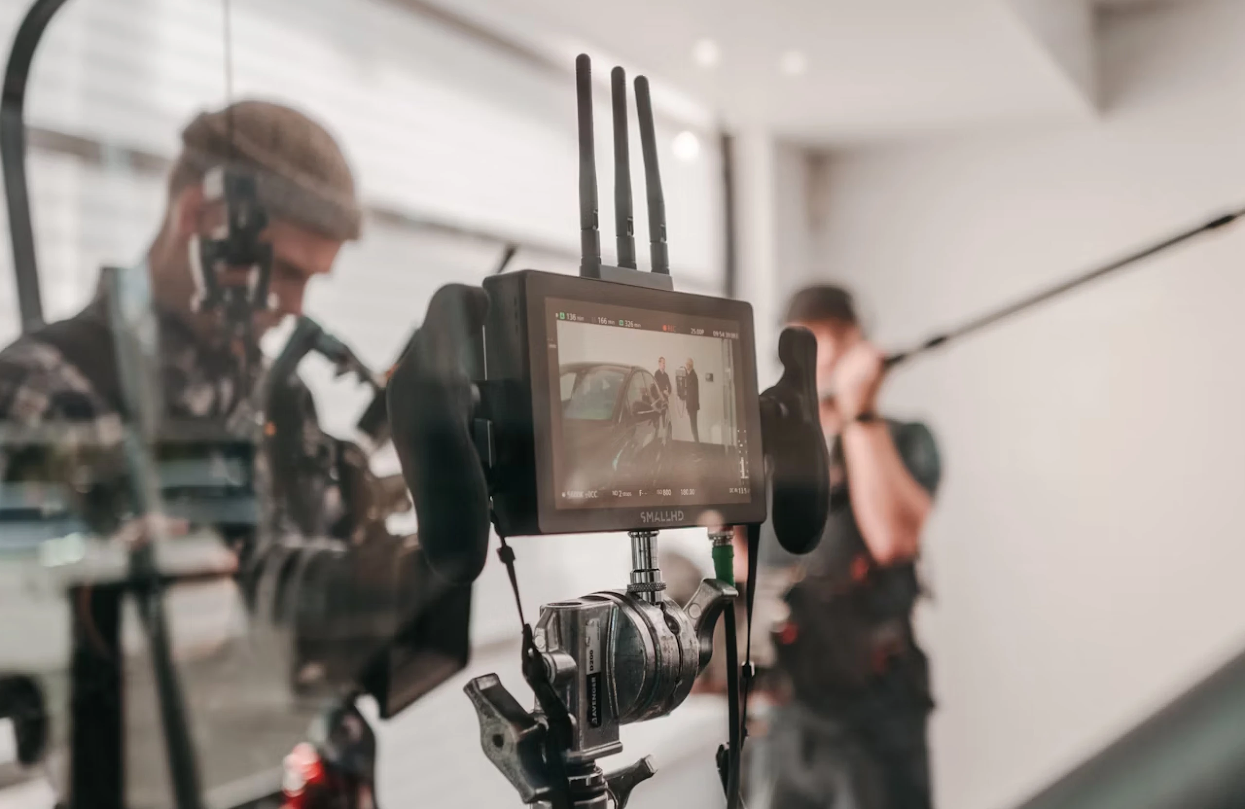 FX Productions Canada A camera monitor displays a film scene with two crew members visible in the background, one holding a boom microphone—capturing the energy of a connected TV commercial production in Canada. Toronto Video Production Company
