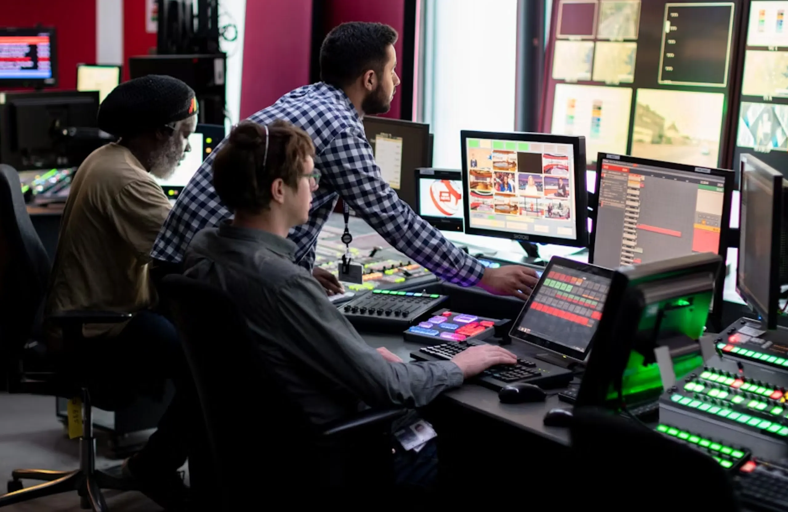 FX Productions Canada Three people work at computer stations in a control room with multiple monitors displaying various screens, buttons, broadcast content, and color grading workflows typical of Vancouver’s bustling post-production scene. Toronto Video Production Company