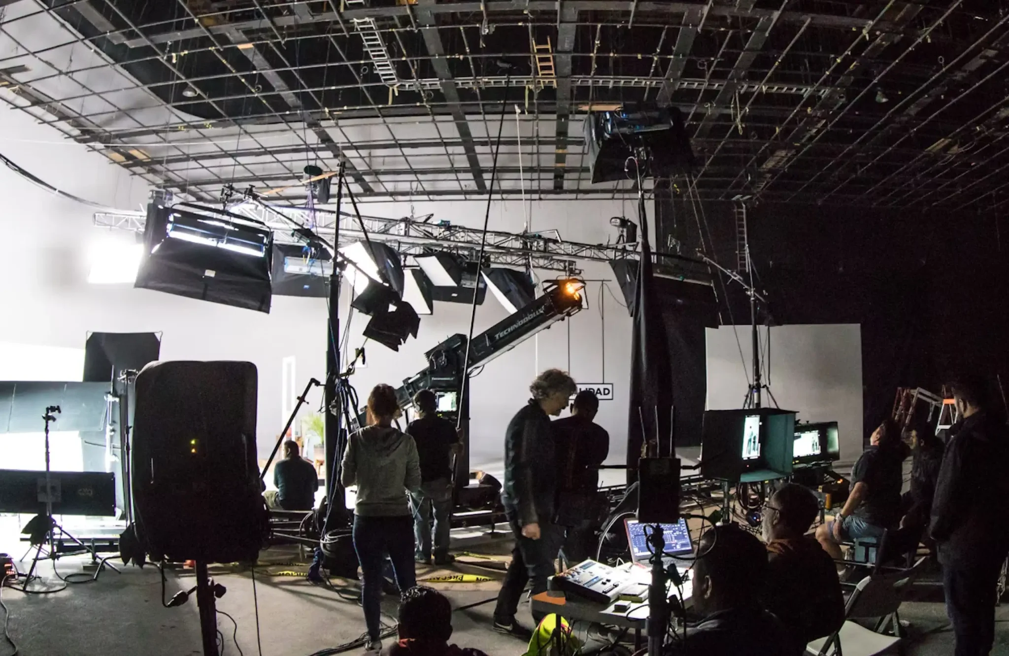 FX Productions Canada Film crew works on a studio set with lighting equipment, cameras, monitors, and props visible; ceiling rigging and cables overhead—expertly capturing the creative energy of product video production in Vancouver. Toronto Video Production Company