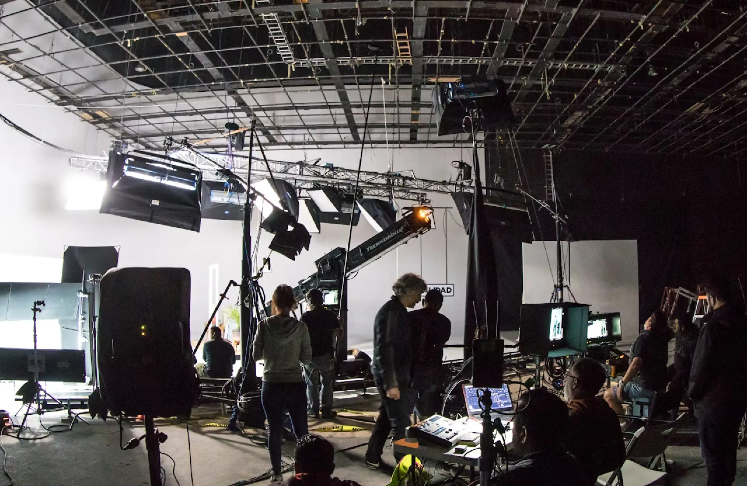 FX Productions Canada Film crew works on a studio set with lighting equipment, cameras, monitors, and props visible; ceiling rigging and cables overhead—expertly capturing the creative energy of product video production in Vancouver. Toronto Video Production Company
